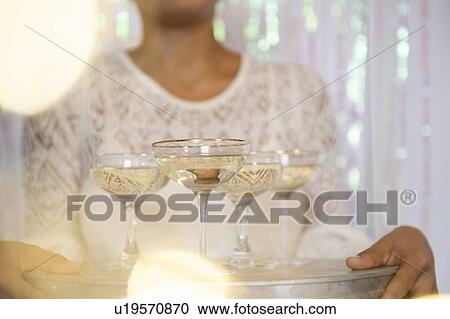 Young woman holding tray with glasses of white wine View Large Photo Image Stock Image - Young woman holding tray with glasses of white wine. Fotosearch