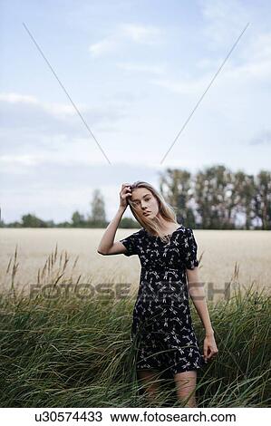 Stock Image - Young woman in field. Fotosearch