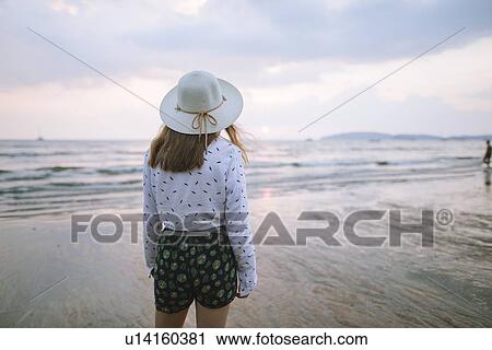 Stock Image - Young woman in sun hat on beach in Krabi, Thailand. Fotosearch