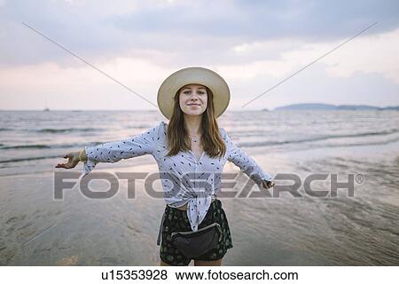 Stock Photo - Young woman in sun hat on beach in Krabi, Thailand. Fotosearch