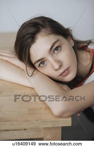 Young woman leaning on wooden table View Large Photo Image Stock Photo - Young woman leaning on wooden table. Fotosearch