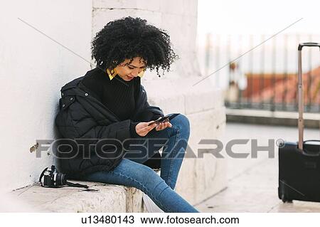 Young woman looking at photographs on bench View Large Photo Image Stock Image - Young woman looking at photographs on bench. Fotosearch