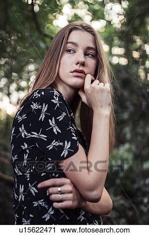 Stock Image - Young woman looking over shoulder. Fotosearch