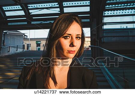 Stock Photo - Young woman on stairway in train station, portrait, Turin, Piemonte, Italy. Fotosearch