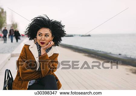 Stock Photo - Young woman on waterfront in Lisbon, Portugal. Fotosearch