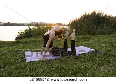 Young woman practicing yoga in park View Large Photo Image Stock Image - Young woman practicing yoga in park. Fotosearch