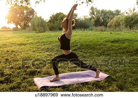 Young woman practicing yoga in park View Large Photo Image Stock Photo - Young woman practicing yoga in park. Fotosearch