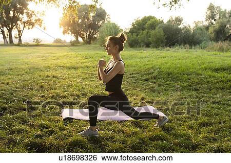 Young woman practicing yoga in park View Large Photo Image Stock Photograph - Young woman practicing yoga in park. Fotosearch
