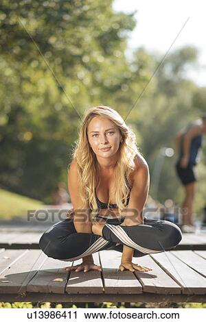 Young woman practicing yoga on boardwalk View Large Photo Image Stock Image - Young woman practicing yoga on boardwalk. Fotosearch