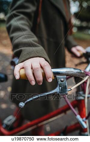 Young woman pushing bicycle in autumn park, close up of hand on handlebar View Large Photo Image Stock Image - Young woman pushing bicycle in autumn park, close up of hand on handlebar. Fotosearch