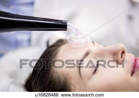 Young woman receiving beauty treatment using a High Frequency Machine in a clinic. The High Frequency Machine uses a glass mushroom shaped electrode filled with argon gas. As the high frequency current is passed down the electrode, an oxygen pocket is... View Large Photo Image Stock Photo - Young woman receiving beauty treatment using a High Frequency Machine in a clinic. The High Frequency Machine uses a glass mushroom shaped electrode filled with argon gas. As the high frequency current is passed down the electrode, an oxygen pocket is.... Fotosearch
