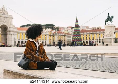 Young woman sitting in town square in Lisbon, Portugal View Large Photo Image Picture - Young woman sitting in town square in Lisbon, Portugal. Fotosearch