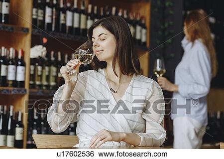 Stock Photograph - Young woman smelling white wine. Fotosearch
