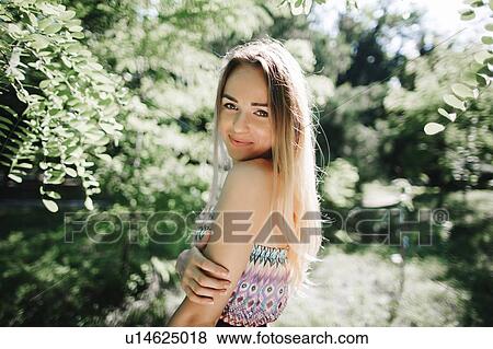 Stock Photo - Young woman smiling in park. Fotosearch