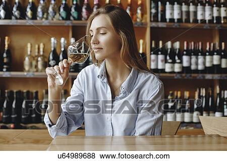 Young woman sniffing glass of white wine View Large Photo Image Stock Photo - Young woman sniffing glass of white wine. Fotosearch