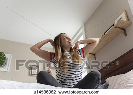 Young woman stretching on bed View Large Photo Image Stock Image - Young woman stretching on bed. Fotosearch