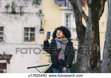 Stock Image - Young woman taking selfie in Lisbon, Portugal. Fotosearch