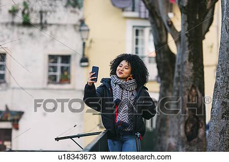 Stock Image - Young woman taking selfie in Lisbon, Portugal. Fotosearch