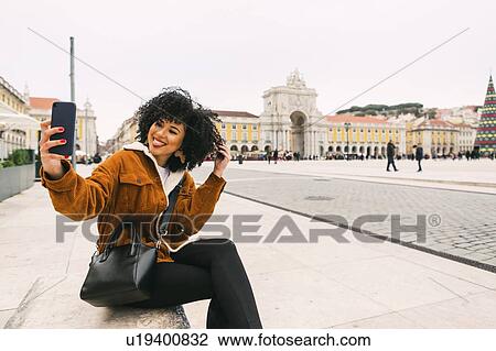 Young woman taking selfie in town square in Lisbon, Portugal View Large Photo Image Stock Image - Young woman taking selfie in town square in Lisbon, Portugal. Fotosearch