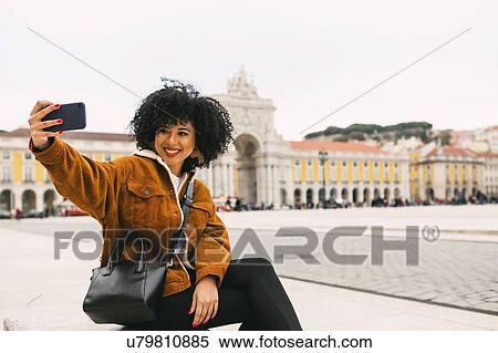 Young woman taking selfie in town square in Lisbon, Portugal View Large Photo Image Stock Photography - Young woman taking selfie in town square in Lisbon, Portugal. Fotosearch