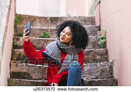 Young woman taking selfie on steps View Large Photo Image Stock Image - Young woman taking selfie on steps. Fotosearch