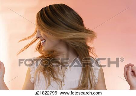 Stock Photograph - Young woman tossing her hair. Fotosearch