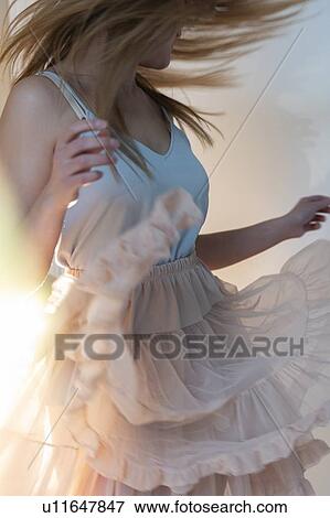 Stock Photo - Young woman tossing her head while dancing. Fotosearch