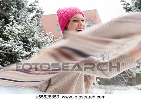 Stock Photo - Young woman twirling with shawl in snow. Fotosearch
