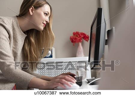 Stock Photo - Young woman using desktop PC. Fotosearch
