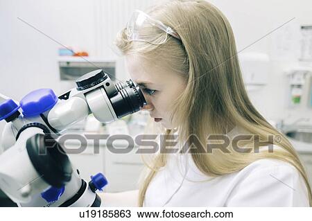 Young woman using microscope View Large Photo Image Stock Image - Young woman using microscope. Fotosearch