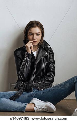 Stock Image - Young woman wearing black leather jacket. Fotosearch