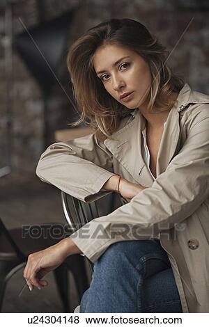 Stock Photo - Young woman wearing grey trench coat. Fotosearch