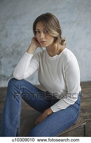 Stock Image - Young woman wearing white sweater. Fotosearch