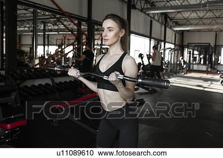 Young woman weight lifting in gym View Large Photo Image Stock Image - Young woman weight lifting in gym. Fotosearch