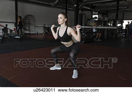 Young woman weight lifting in gym View Large Photo Image Stock Image - Young woman weight lifting in gym. Fotosearch