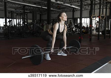 Young woman weight lifting in gym View Large Photo Image Stock Photo - Young woman weight lifting in gym. Fotosearch