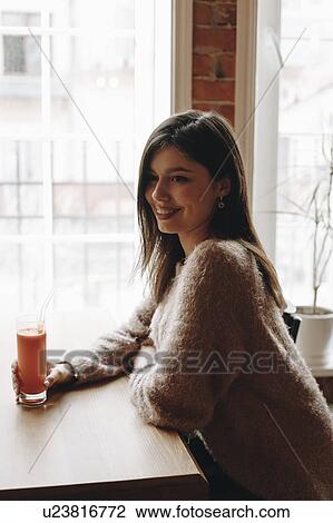 Stock Image - Young woman with carrot juice. Fotosearch