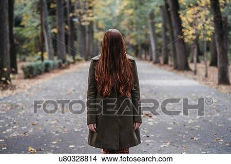 Young woman with long red hair covering her face in autumn park, portrait View Large Photo Image Picture - Young woman with long red hair covering her face in autumn park, portrait. Fotosearch