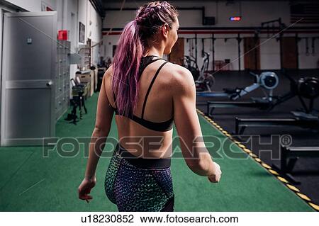 Young woman with plaited purple hair walking through gym View Large Photo Image Stock Image - Young woman with plaited purple hair walking through gym. Fotosearch