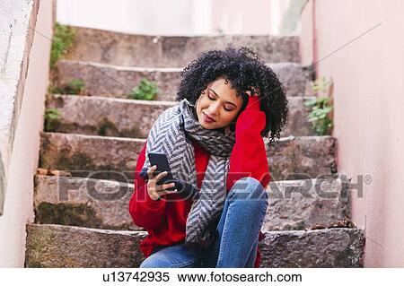 Young woman with smart phone sitting on steps View Large Photo Image Stock Photography - Young woman with smart phone sitting on steps. Fotosearch