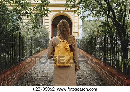 Young woman with yellow backpack walking in park View Large Photo Image Stock Image - Young woman with yellow backpack walking in park. Fotosearch