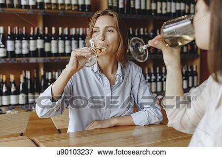Young women drinking white wine View Large Photo Image Stock Photo - Young women drinking white wine. Fotosearch