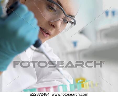 Picture - Biotechnology research. Scientist pipetting sample into a microcentrifuge tube ready for automated analysis.. Fotosearch