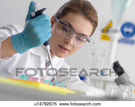 Stock Photography - Biotechnology research. Scientist pipetting sample into a microcentrifuge tube ready for automated analysis.. Fotosearch