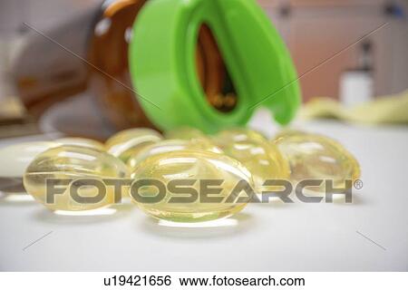Stock Photograph - Capsules spilling from bottle.. Fotosearch