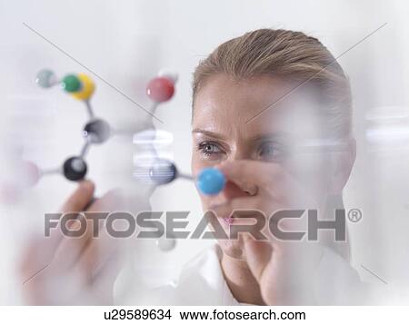 Chemistry research, conceptual image. Scientist using a molecular model to understand a chemical formula. View Large Photo Image Picture - Chemistry research, conceptual image. Scientist using a molecular model to understand a chemical formula.. Fotosearch