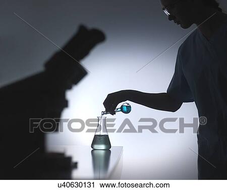 Chemistry research. Scientist pouring a chemical formula into a flask during an experiment. View Large Photo Image Stock Image - Chemistry research. Scientist pouring a chemical formula into a flask during an experiment.. Fotosearch