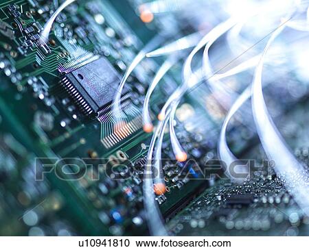 Stock Image - Digital communication, conceptual image. Fibre optics carrying data over electronic circuitry on a laptop computer.. Fotosearch