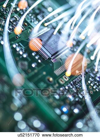 Stock Image - Digital communication, conceptual image. Fibre optics carrying data over electronic circuitry on a laptop computer.. Fotosearch
