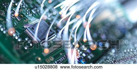 Stock Photo - Digital communication, conceptual image. Fibre optics carrying data over electronic circuitry on a laptop computer.. Fotosearch